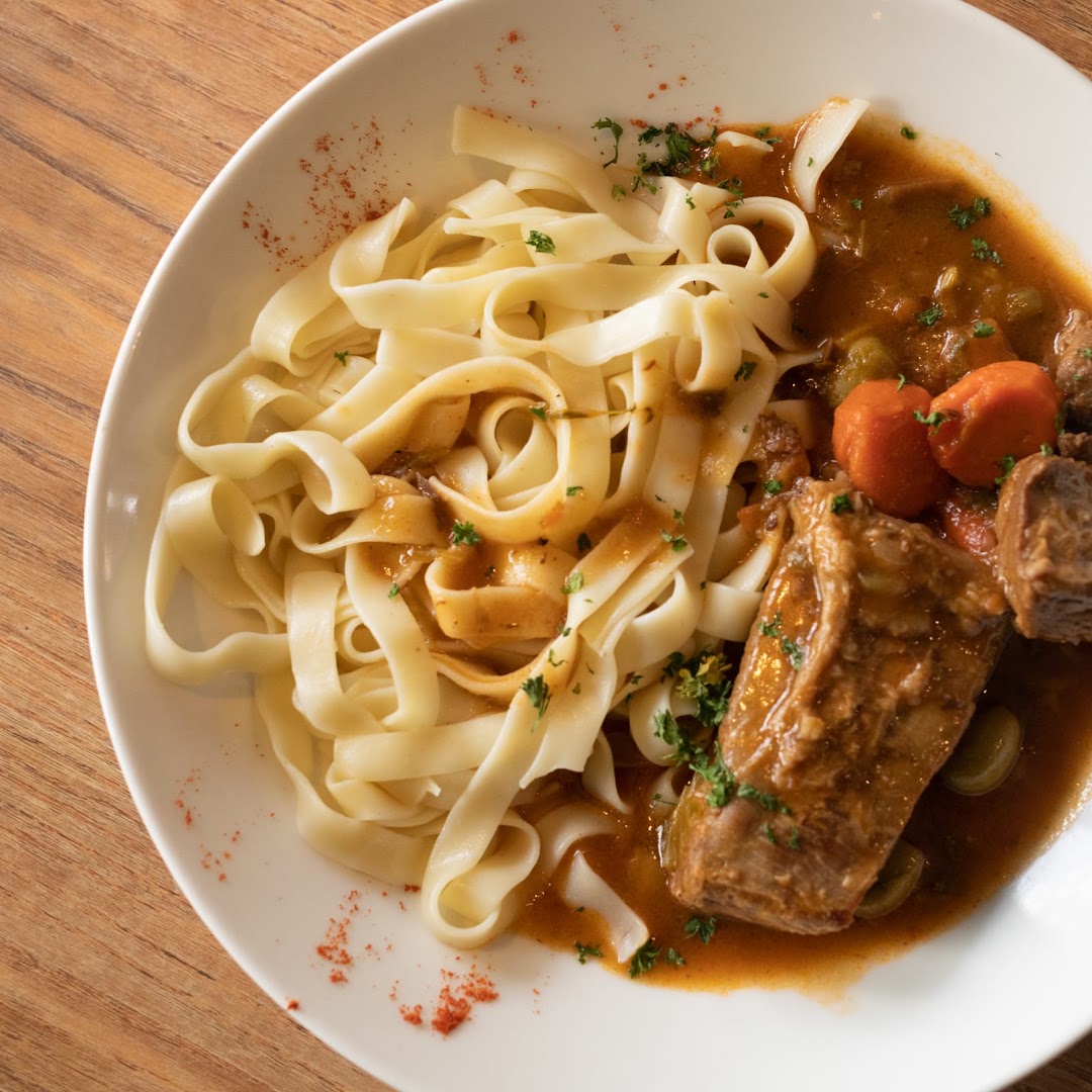 Des pâtes larges accompagnées de viande mijotée