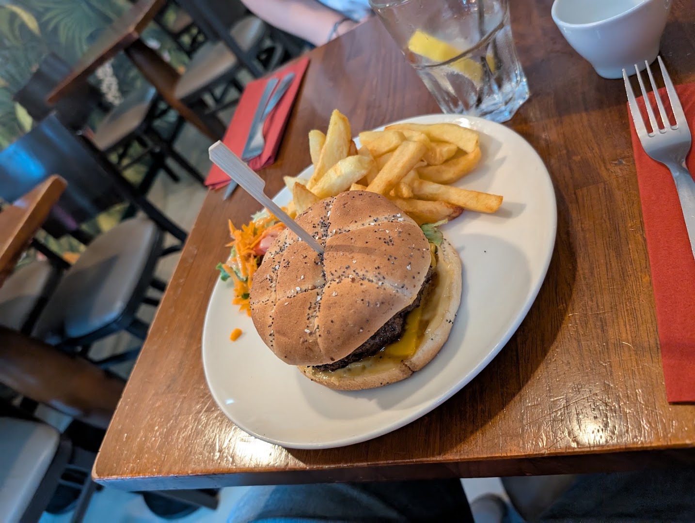 Un burger avec frites sur une table dressée